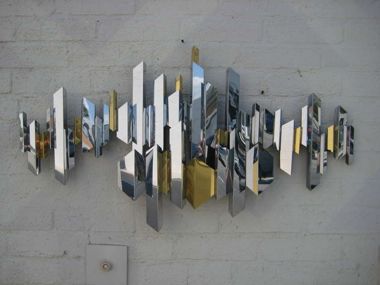 A sparkling chrome and brass cityscape wall sculpture by C. Jere. C.1970's. In Excellent Condition In Palm Springs, CA