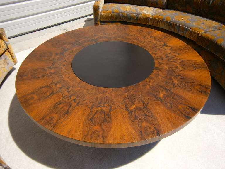 An extraordinary revolving rosewood, black laminate and painted wood cocktail table designed by Milo Baughman for Thayer Coggin Inc.  Circa 1969.  This table is composed of a circular 