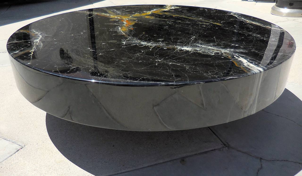 A dramatic floating circular coffee table fabricated from resin-coated enameled lacquer on a wooden substrate and raised on a discreet recessed base.  This table is from the 1970's and is attributed to an Italian company named Ceccarplast.  The