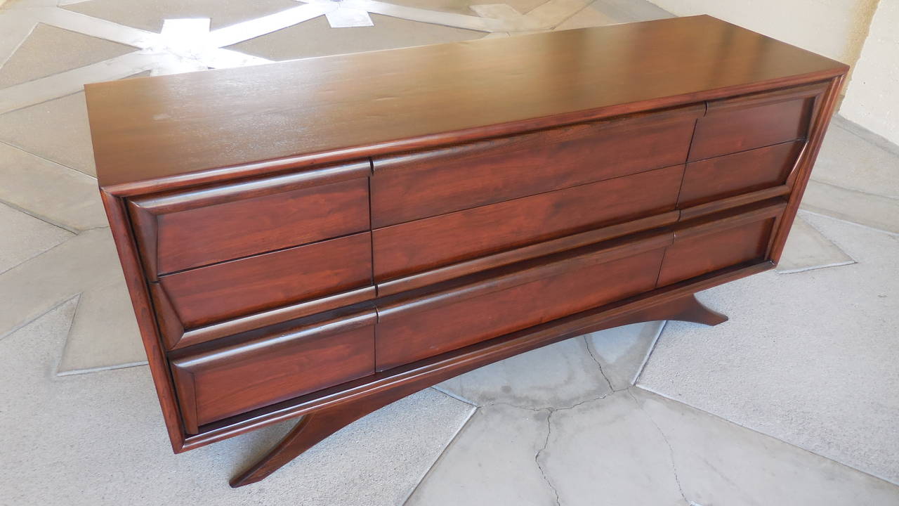 A stylish nine-drawer walnut chest made by Kroehler Furniture in the 1960s. Stylistically, the chest makes reference to the extraordinary designs of Vladimir Kagan, particularly in the raised, splay-legged base. The chest has been professionally