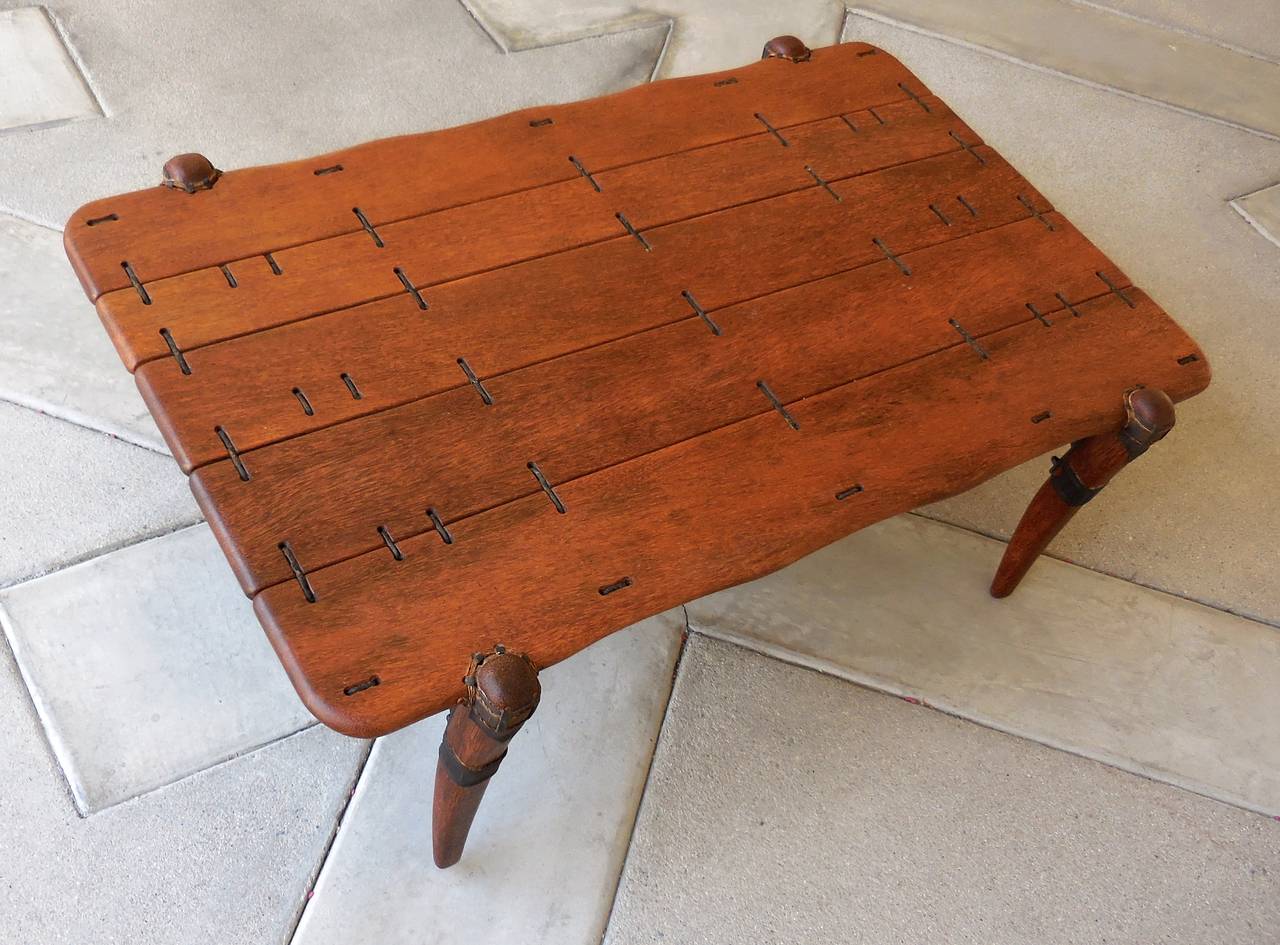An intriguing vintage palm wood and leather coffee table. The grain of the palm wood is unique and the leather bindings that hold this table together (along with the steel struts on the bottom side) create an interesting pattern. Acquired from a