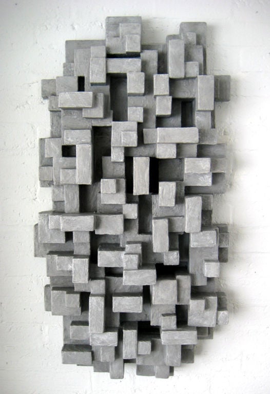 A wall mounted sculpture by American sculptor Dan Schneiger.<br />
Dan is captivated by the works of Louise Nevelson, Picasso and Richard Neutra. Dan's sculptures are hand built assemblages of new and reclaimed materials including wood, fiber