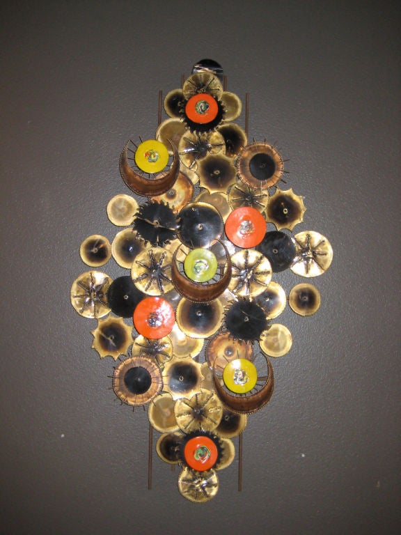 A torch-cut brass and enamel wall sculpture