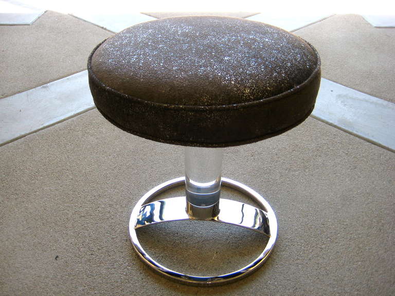 A Charles Hollis Jones swiveling vanity stool with an acrylic column mounted into nickel plated steel.  C.1970's.  This piece has been newly reupholstered in a shimmery silver grey fabric and the metal has been replated.
