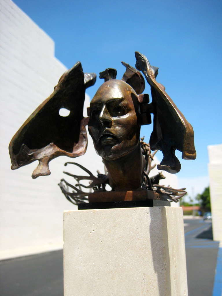 A Surrealist bronze sculpture by American Artist Ted Gall (American B. 1941). The concept of this sculpture is that the bronze horse head hinges open to reveal a human head. The face in turn, hinges up to reveal a bizarre scene of cowboys and horses
