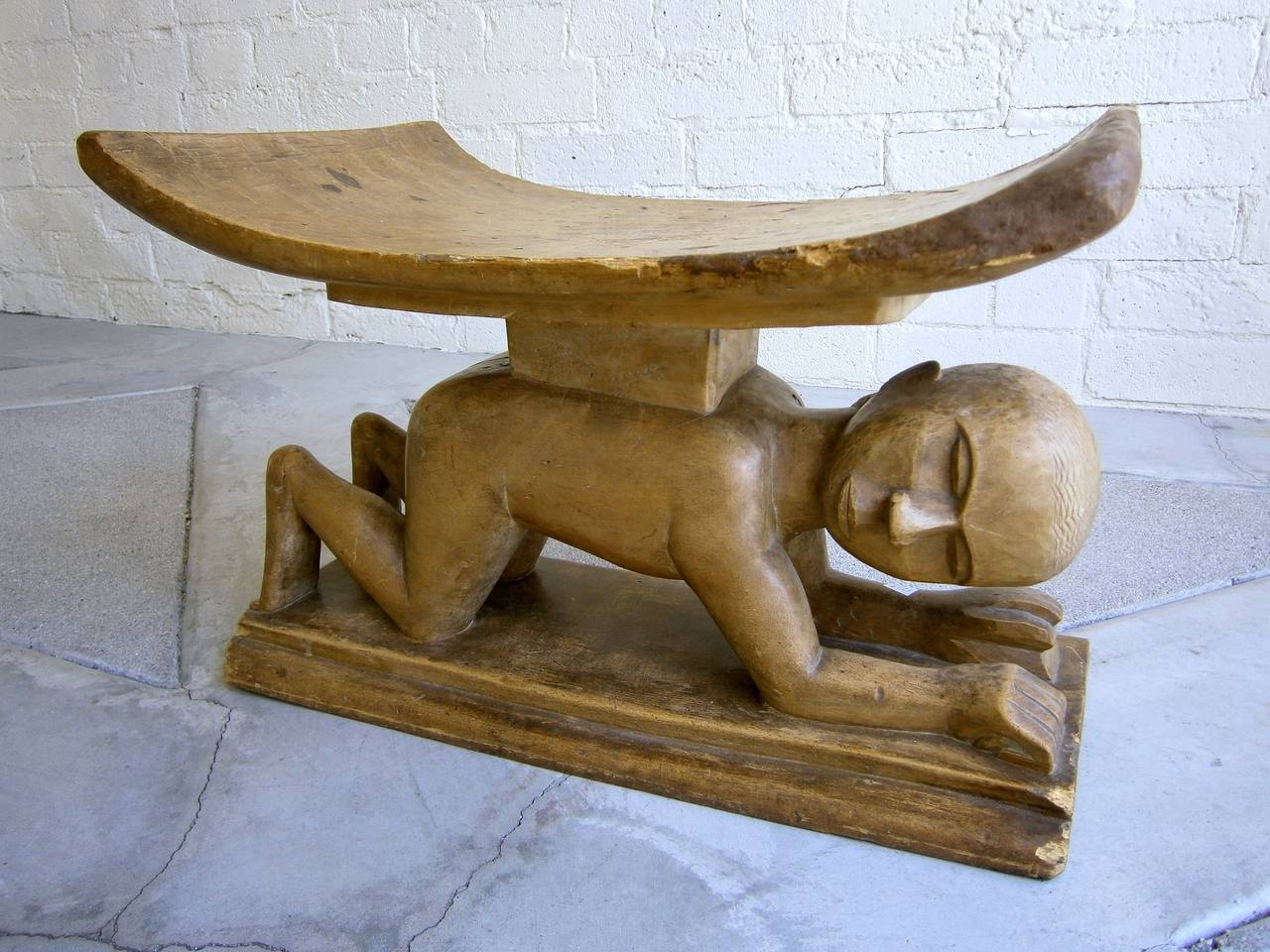 A rarely seen figural Ashanti Stool. Made of African hardwood and carved out of a single block, these stools have deep spiritual significance to the Ashanti people. The belief is that the stool is the 