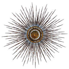A gilt metal and steel sunburst wall sculpture by William Bowie  C. 1960's