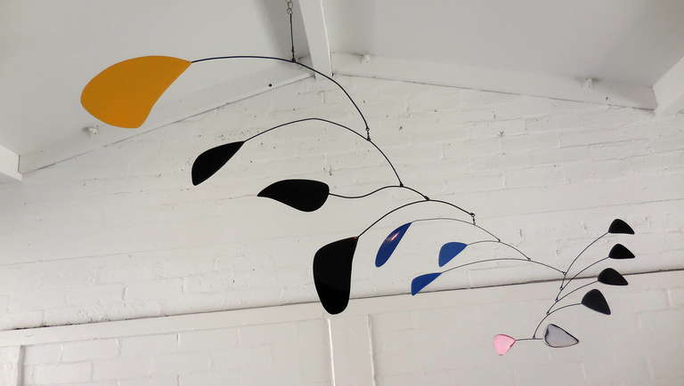 A large scale and lyrically inspiring welded steel mobile in the manner of Alexander Calder. the color progression from the top to the bottom is Yellow/Black/Blue/Black and finally Red. The photographs show the 
piece in its various positions. It