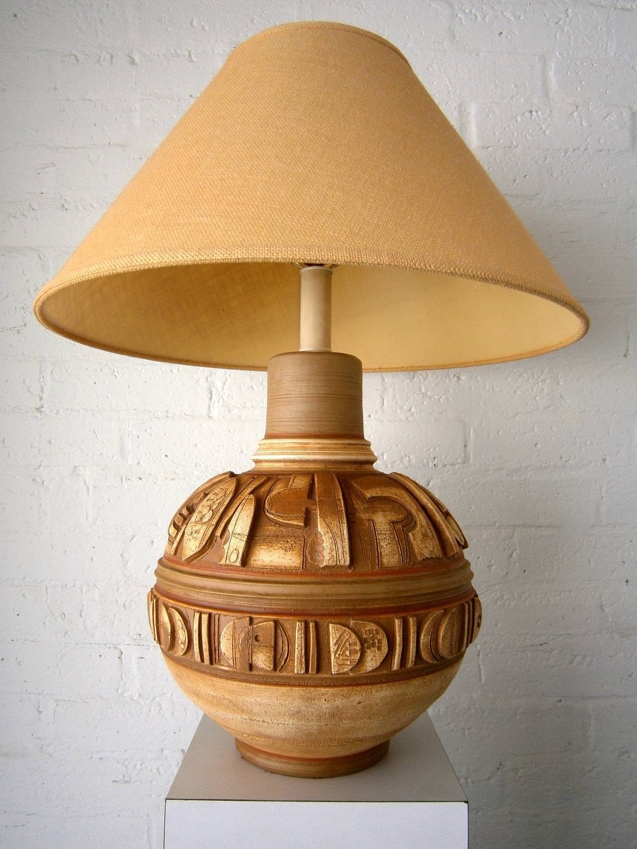 An imposing Mid-Century table lamp by Casual Of California from the 1970s.  The large molded ceramic body of the lamp has been hand-decorated with incised lines and details and then fired with a subtle polychromed glaze.  The base is signed Casual