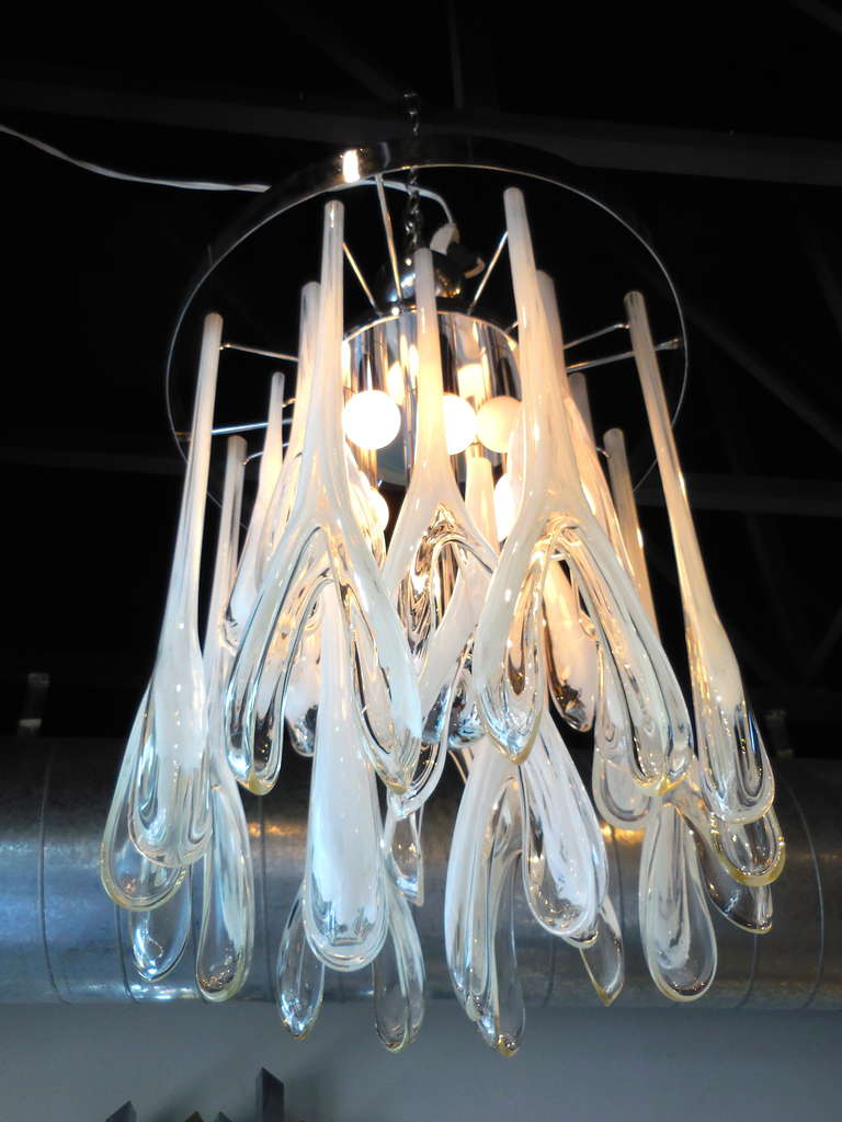 A unique Murano glass chandelier with hand-blown clear and white glass components that resemble wishbones.  The glass elements hang from a chrome plated ring that can be hung close to the ceiling if necessary.  This piece is attributed to the