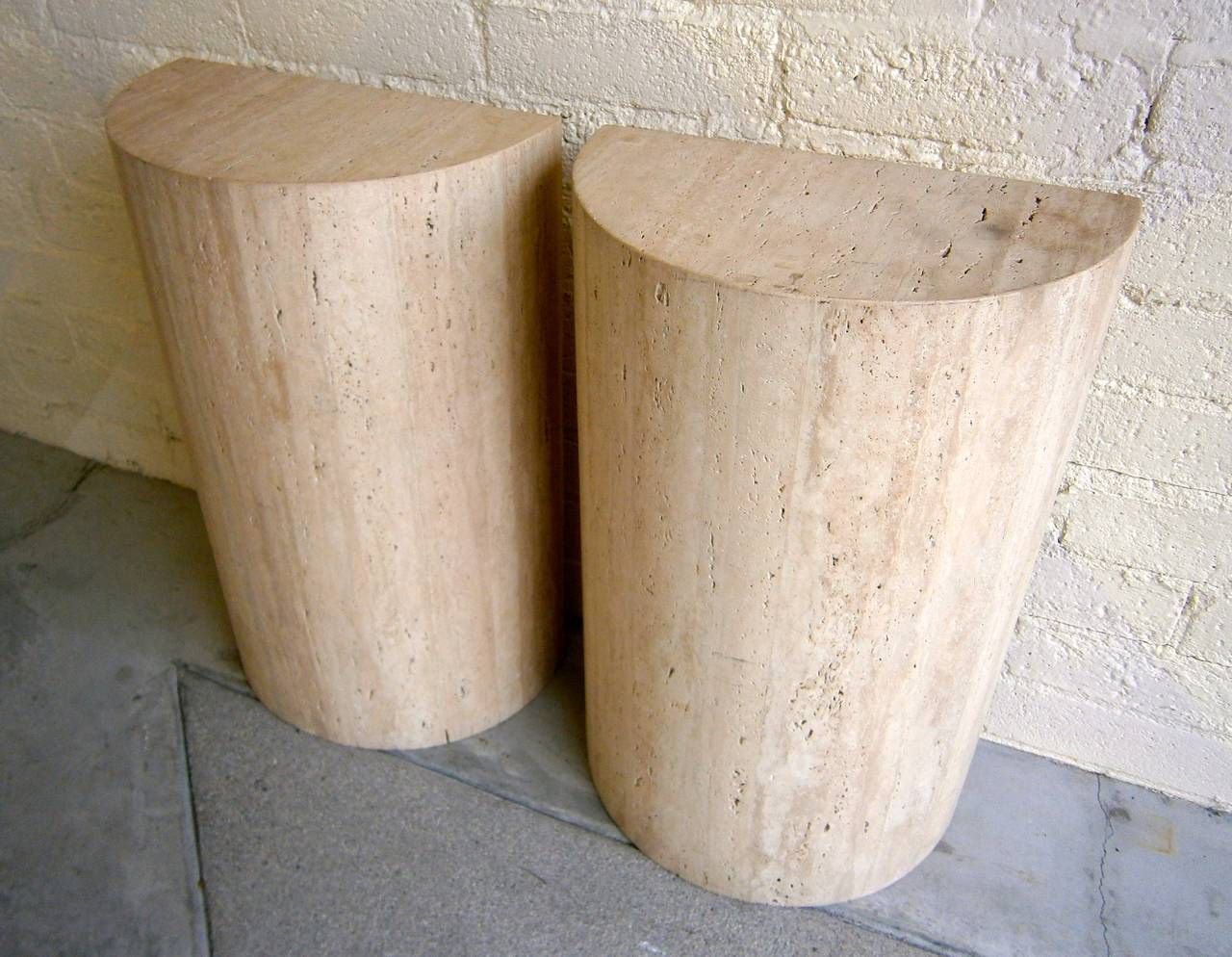An imposing pair of travertine semi-circular table bases from the 1970s.  Each of the bases is finished on all sides and can be used with a glass top as a console table or they can stand alone as individual pedestals.  Sold only as a pair.