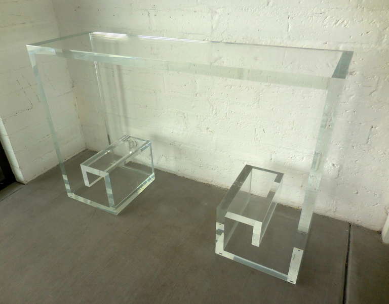 A rectangular Lucite console table with a Greek key inspired design, fabricated by Carmichael of Rancho Mirage, CA in the 1980s. The shallow design of the console makes it perfect for use in an entry way or living area. The Lucite is 1.25
