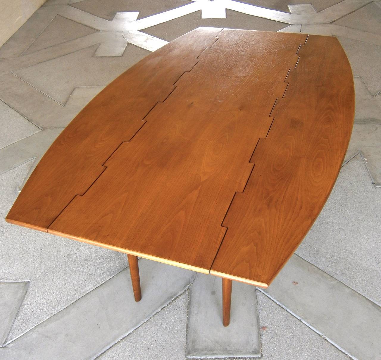 A walnut drop-leaf dining table designed in the 1960s by Barney Flagg for Drexel Furniture's 