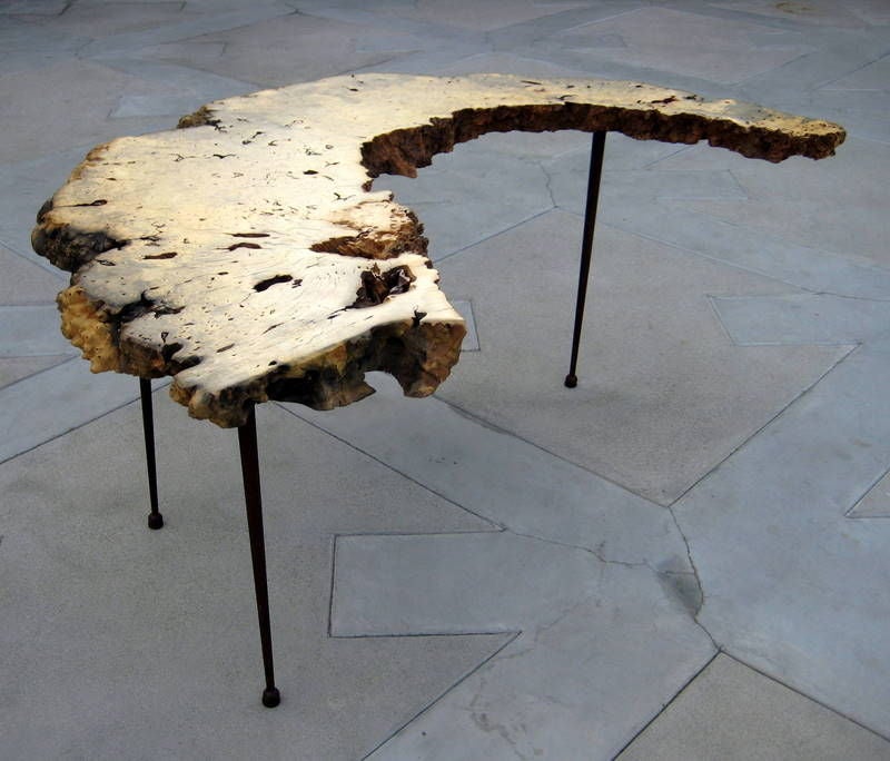An Asian burl root crescent shaped table on three legs