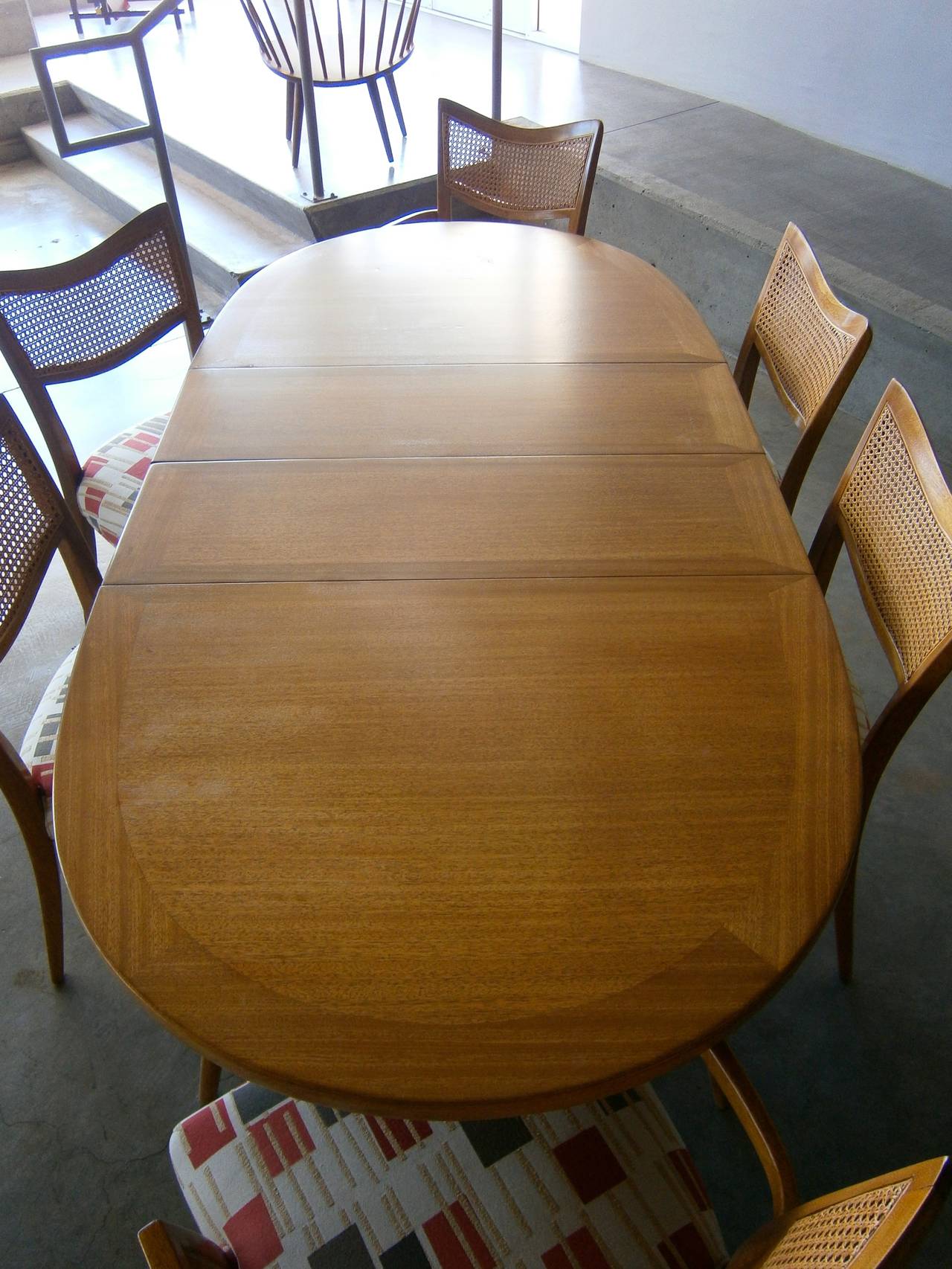 A marvelous bleached mahogany dining room set comprising an oval dining table and 6 chairs designed by Harvey Probber in the 1950s. The wood on all of the pieces in the set is a combination of solid and veneered mahogany that has a beautiful