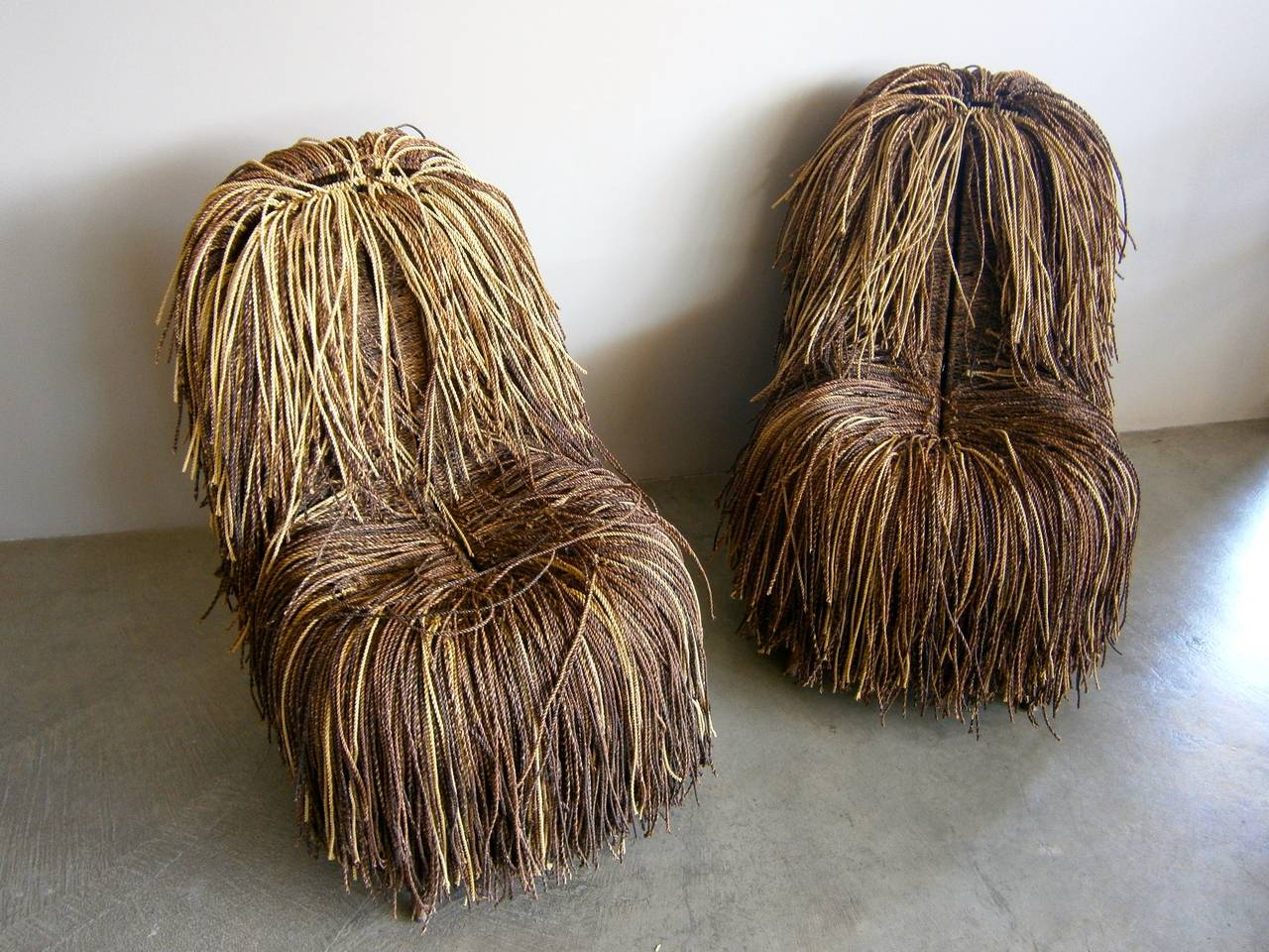 A whimsical and wonderful pair of shaggy cord/rope chairs reminiscent of the brilliant work of the Campana Brothers. Variegated tones of stranded cord are individually woven onto a custom made metal frame built to receive this deep and random