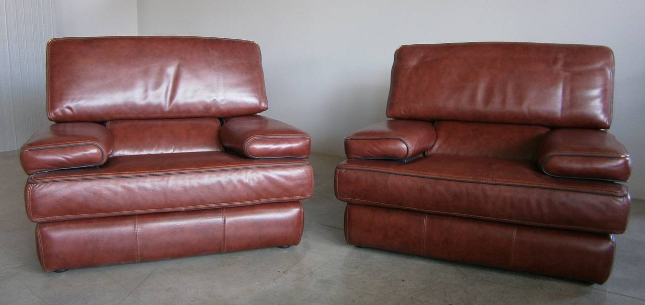An imposingly handsome pair of leather club chairs in the style of De Sede.
Great lines and detailing, high quality leather upholstery, creatively attractive lumbar support cushions and high style all come together beautifully in this wonderful