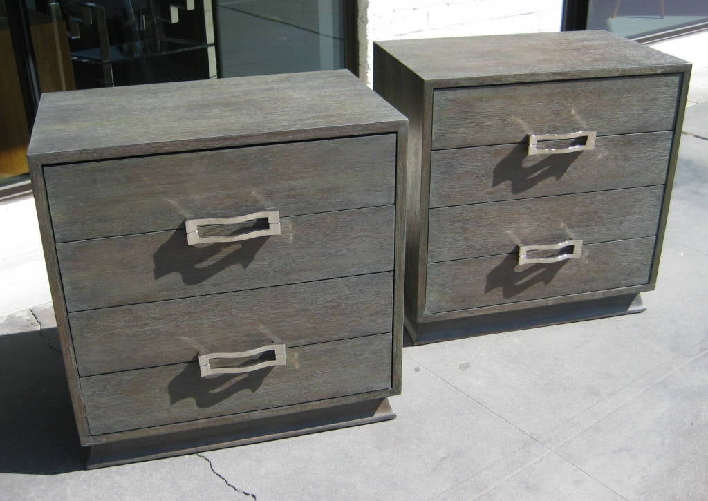 A pair of cerused nightstands with nickle "buckle" pulls