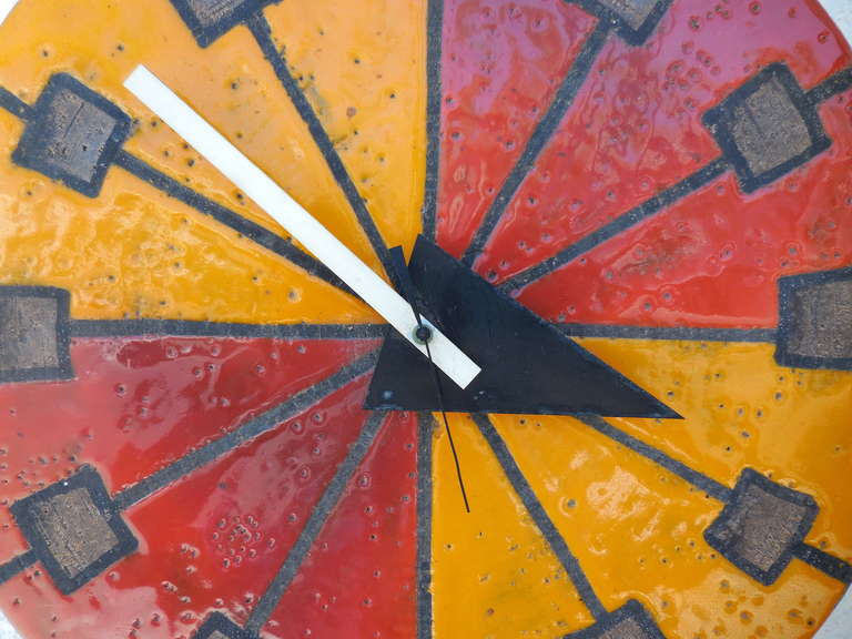 A vibrantly glazed ceramic wall clock designed by Aldo Lundi and made by the Meridian Division of the Howard Miller clock company in the 1970s. The four time quadrants on the face of the clock alternate between orange and red, with brown squares in