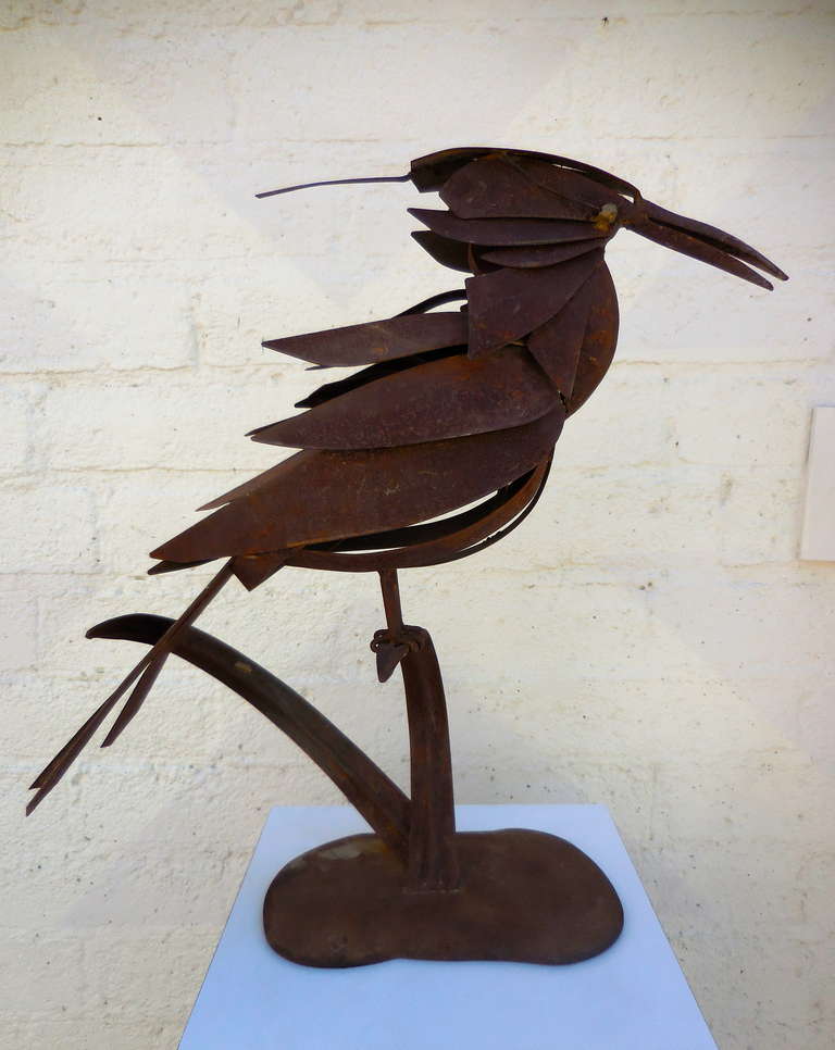 A vintage unsigned 1980s metal sculpture of a large crow sitting on a leaf.  The artist has successfully fabricated welded and assembled cut metal pieces to render the birds feathers and physical characteristics. The metal has oxidized to a