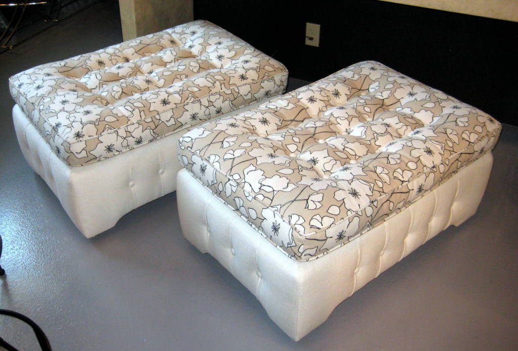A pair of large fully upholstered ottomans on casters