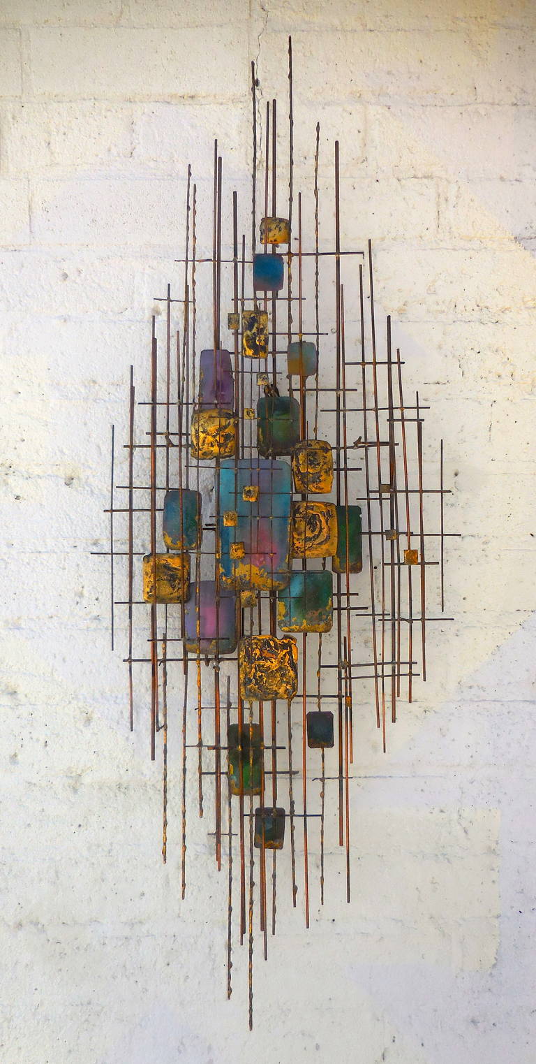 A beautifully scaled 1950s gilded metal and enamel wall sculpture.
The multilayered gilded lattice framework has a multitude of hand enameled
squares and rectangles strategically positioned to form a wonderful abstract composition.