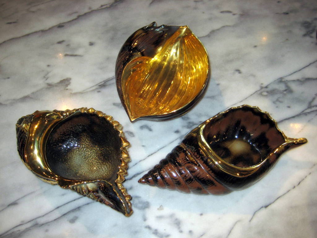 A set of three large scale 24K gold leaf decorated porcelain sea shell bowls by Italian luxury designer Mario Buccellati.
These bowls are quite large with the longest being 14