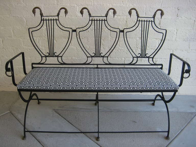 Chic, glamorous and uncommon...an Italian iron and bronze triple lyre-back settee from the 1950's.  The settee has foot and swans head details, along with bronze rings at the end of each arm.  Newly reupholstered in a Greek Key patterned black and