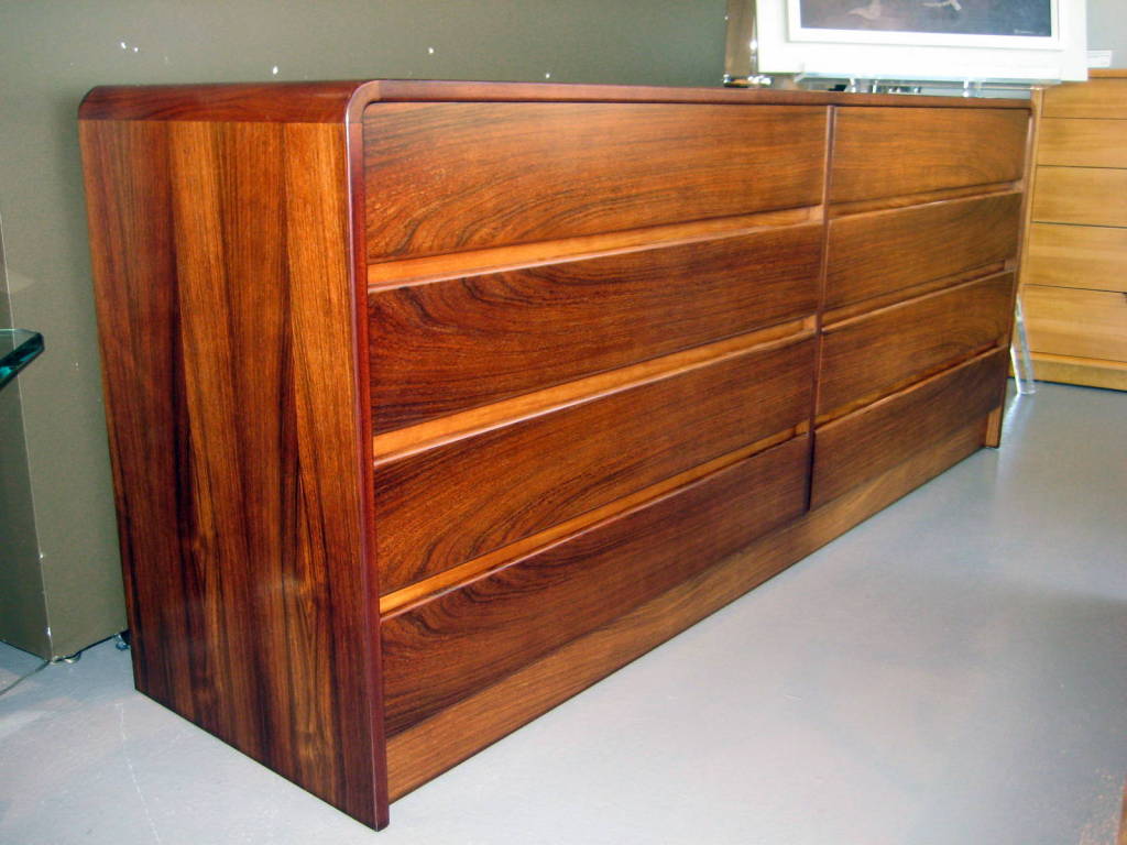 A 1970's book-matched rosewood 8 drawer chest with waterfall edge.
The top 4 drawers and the bottom 4 drawers form closed book matched
oval patterns.