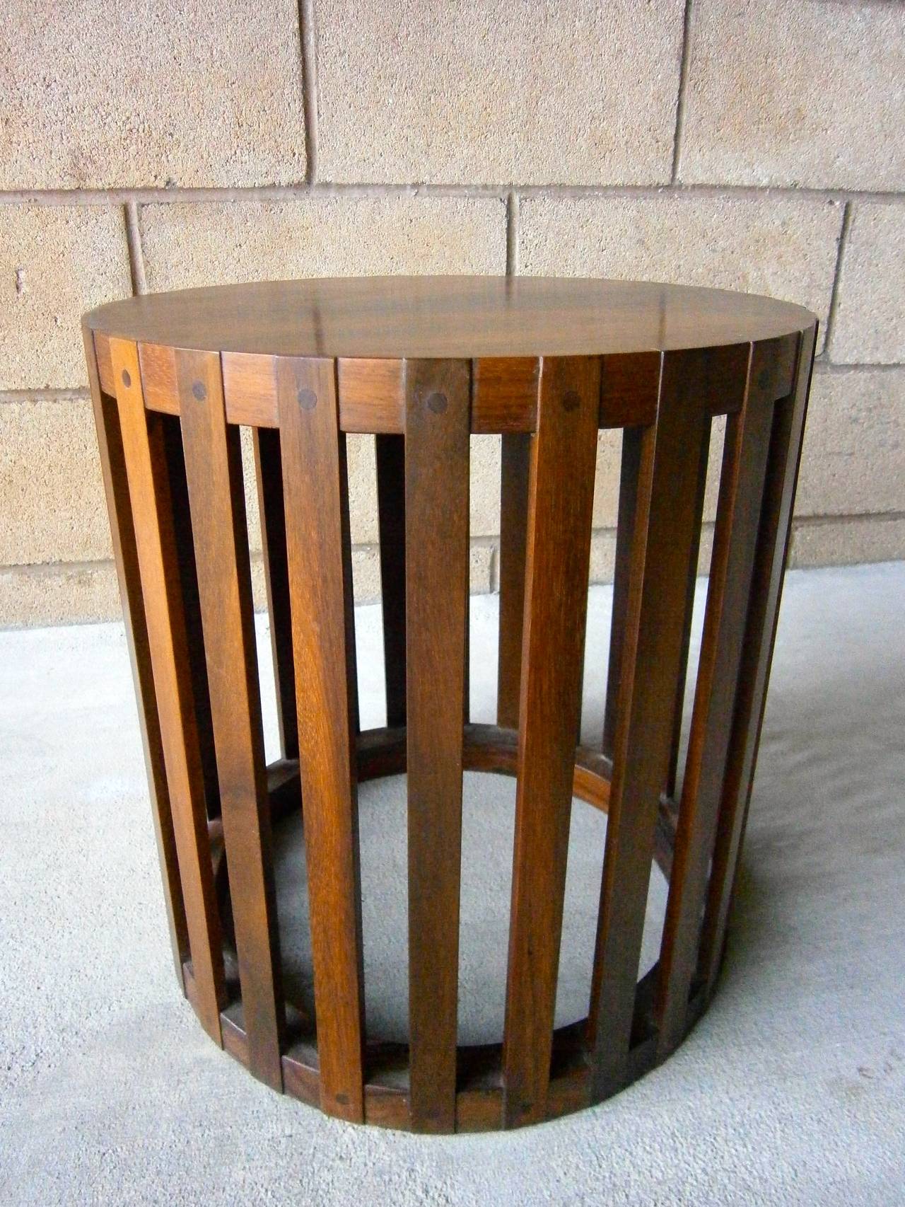 A small circular solid rosewood occasional table from the 1970s.  The slatted sides are attached to the top and to the bottom ring with wooden pegs. This splendid table would be fantastic in any interior.