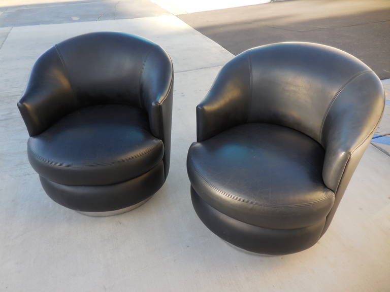 A pair of Karl Springer black leather upholstered club chairs on chrome bases, circa 1980. A fabric upholstered example of the chairs is found in the Karl Springer catalogue. Extremely comfortable and in excellent original condition.