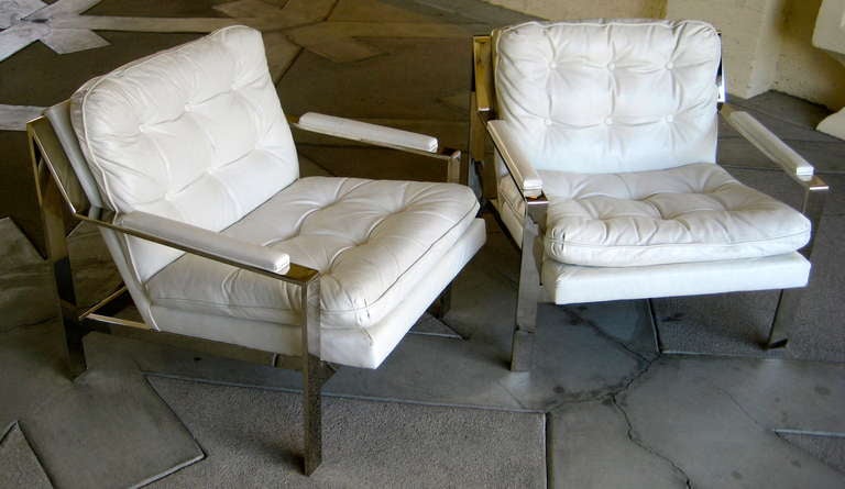 A pair of Cy Mann classic white leather lounge chairs c.1970's. These chairs are in their original white leather upholstery which remains in very good condition.