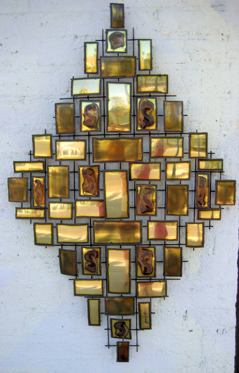 A metal wall sculpture in a layered welded construction consisting of polished and burnished brass elements arranged in a horizontal and vertical composition. Can hand either way.Signed 