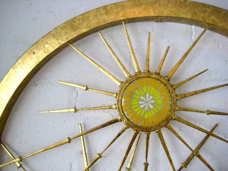 One of a series of rondo wall sculptures produced by California artist Del Williams.  Hand made glass and steel star bursts are layered and incorporated into a circular metal frame in an asymmetrical pattern.  The entire sculpture has been gold