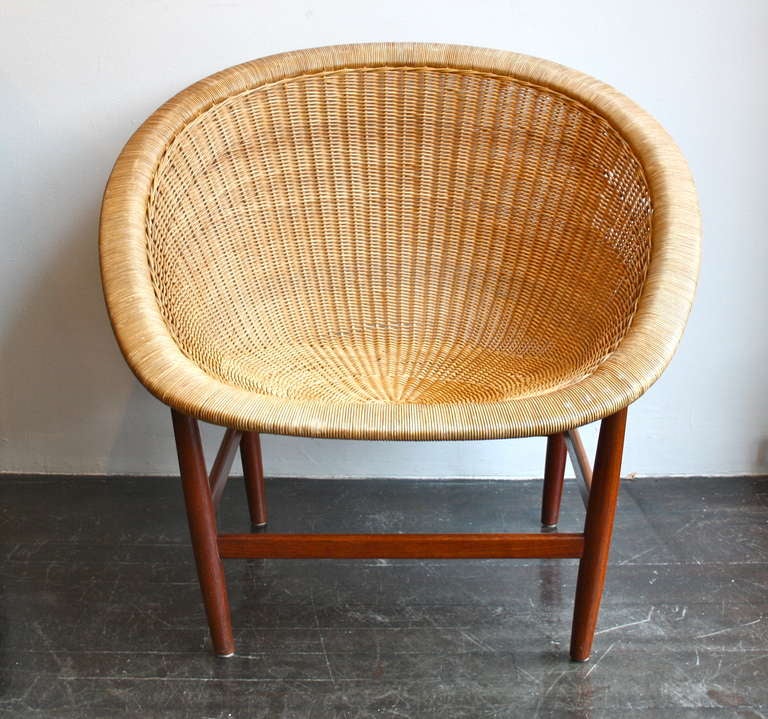 This chair by Nanna Ditzel is sometimes referred to as the Pontoppidan chair, after Ludwig Pontoppidan, who produced the chair at the beginning of 1950s in Copenhagen. It features solid turned mahogany legs and stretcher, and woven wicker