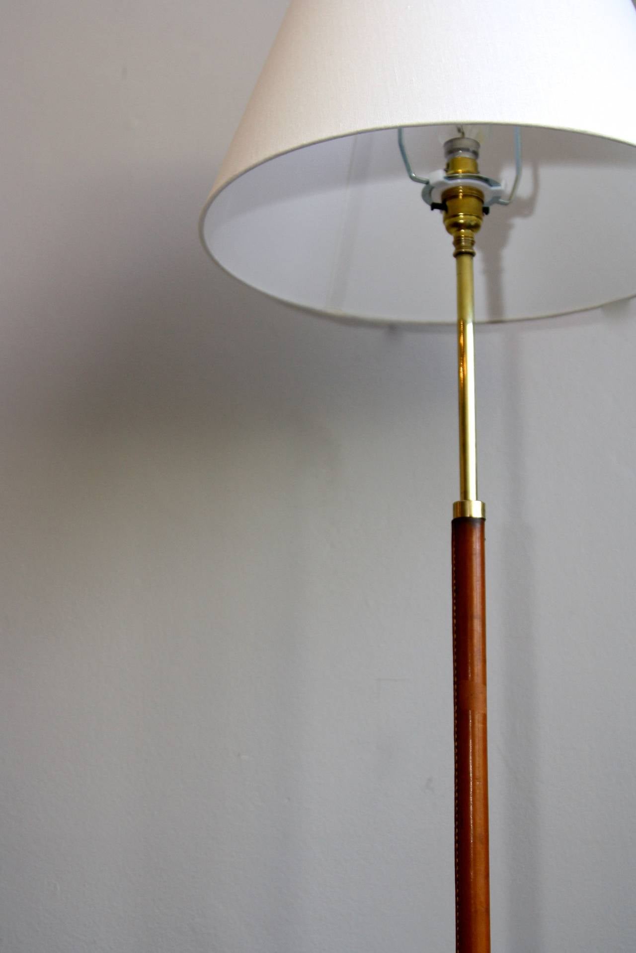 Adjustable floor light in brass with a leather covered stem.