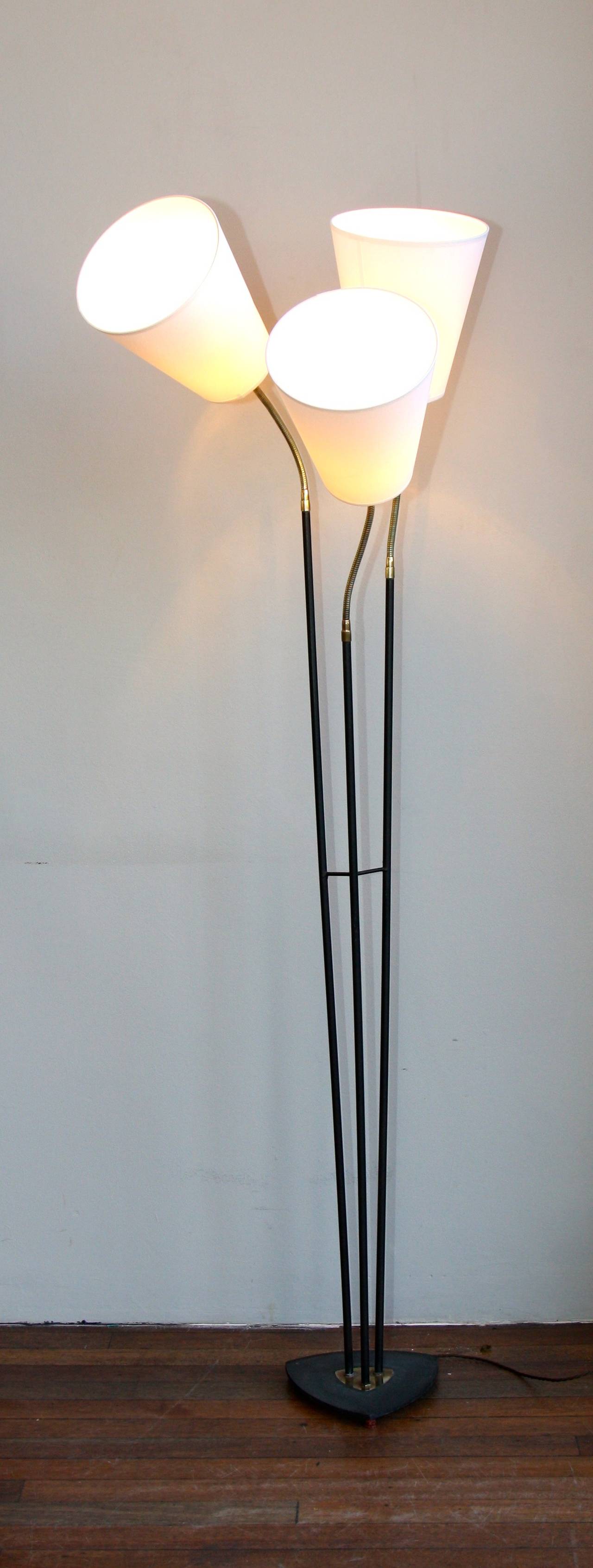 Fully flexible three armed floor light. Black painted metal base and brass details.