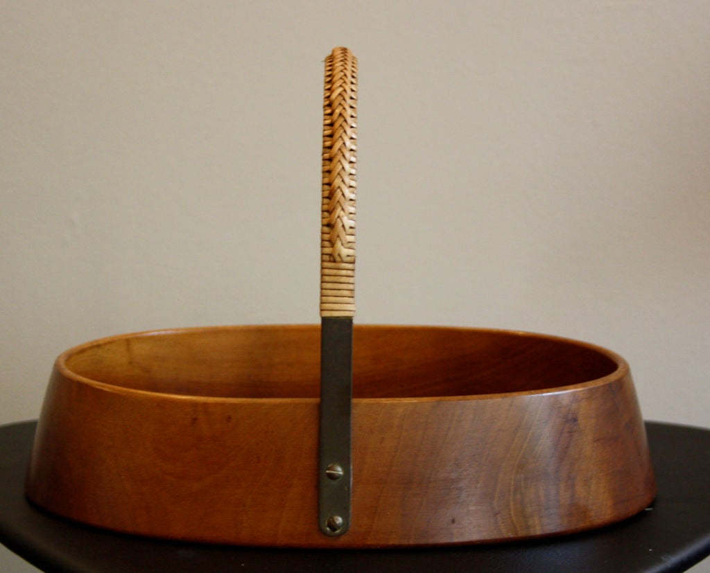 Solid Walnut bowl carved from one piece of wood with a caned brass handle. A fantastic patina on the wood makes this piece special and adds to the strong design by Auboeck underlining why he is considered a modern master