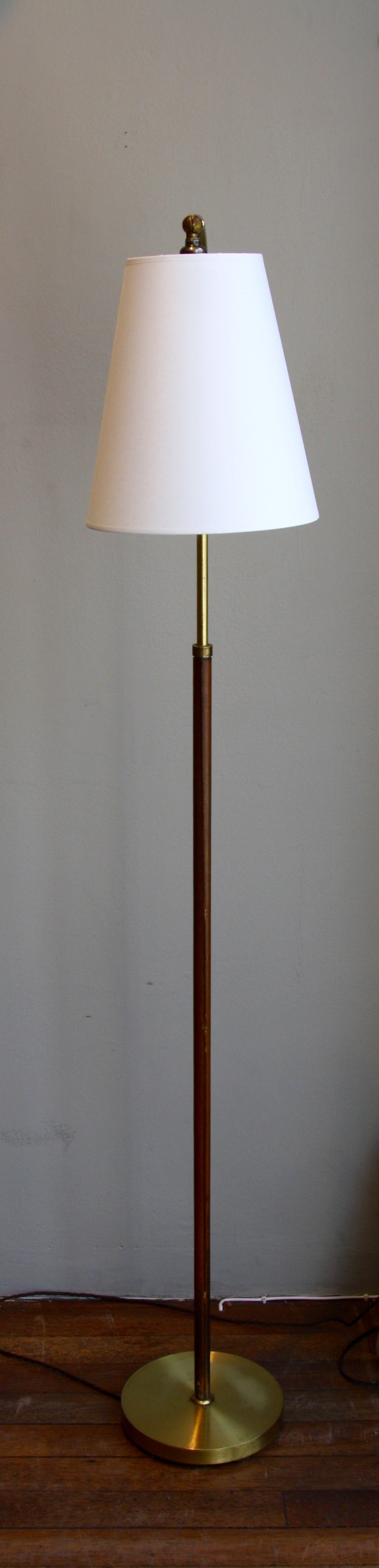 Brass and leather floor light with a tilted head. Height adjustable.