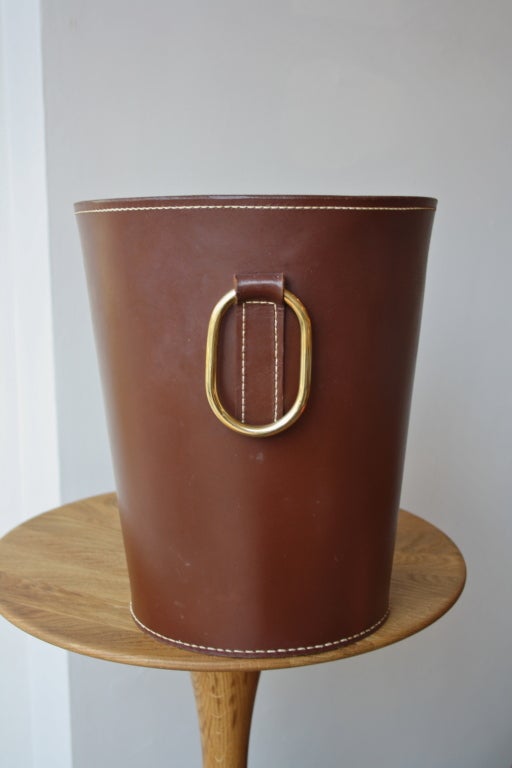 Brown leather sticked wasterpaperbasket with a large brass handle designed by Carl Aubock and made in his workshop in the 1950s