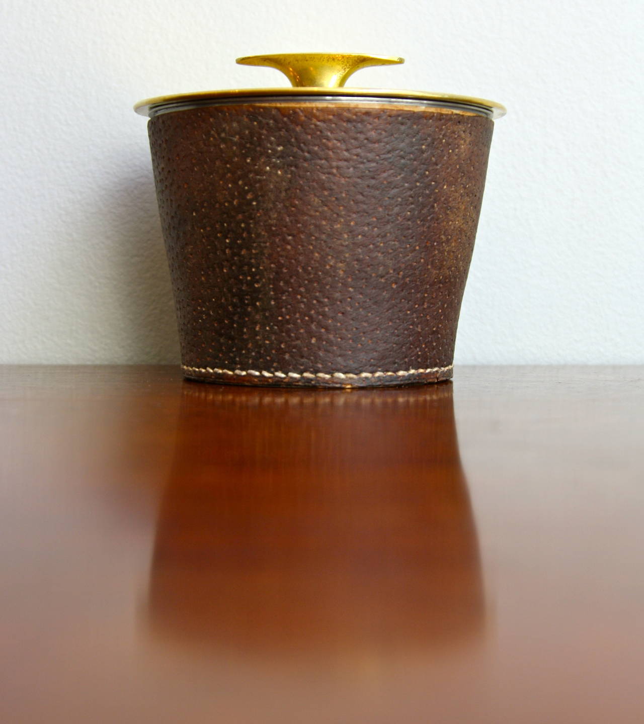 A Wonderful Leather covered tobacco jar by the brass master Carl Auböck. 
A  strong quality piece demonstrating the skill of the small workshop based in Vienna. Lovely brass detailing on the lid and hand stitching on leather base cover.