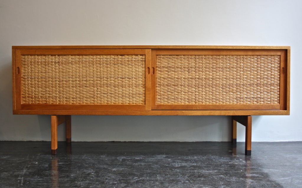 Oak and wicker sideboard , the legs fitted with Rio Rosewood shoes designed by Hans Wegner, Made by Ry Moebler. 
In fantastic condition internally and externally.