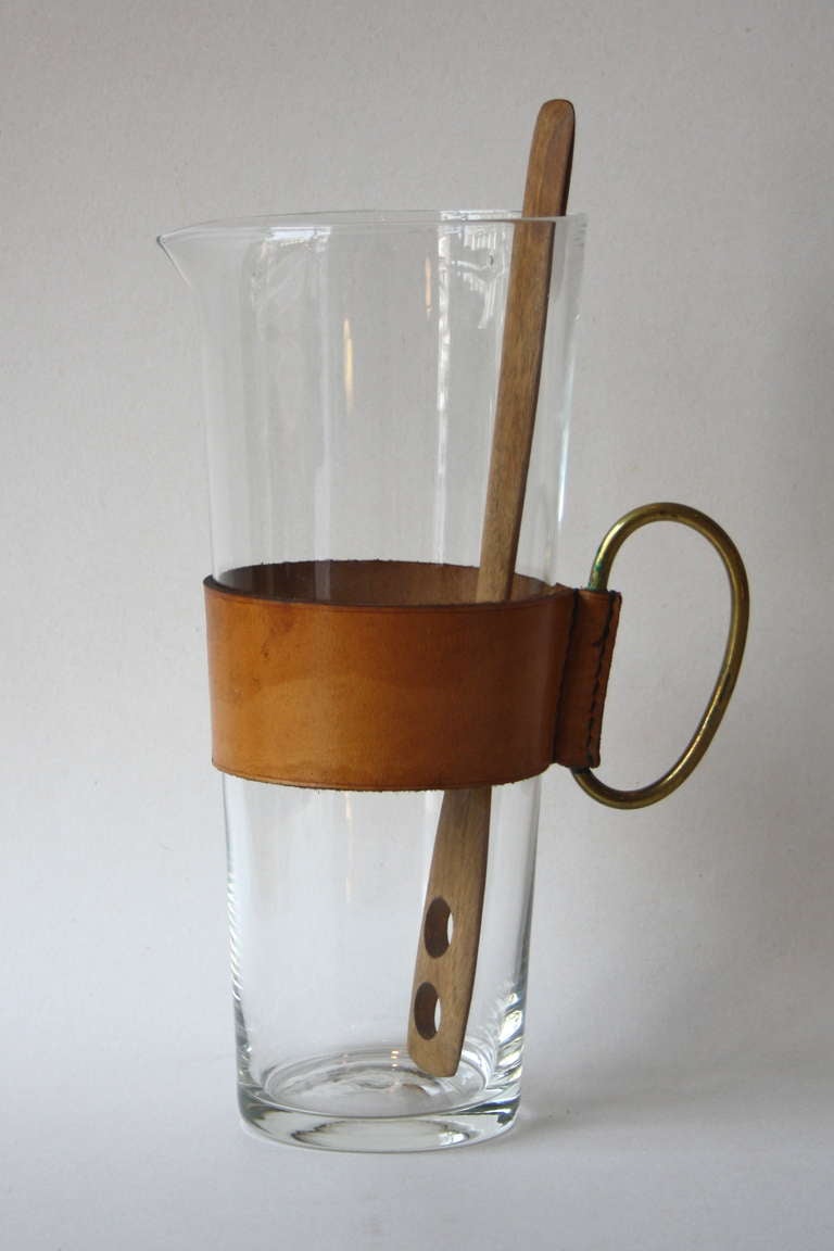 Large glass pitcher with a cognac leather holder and brass handle by Carl Aubock.