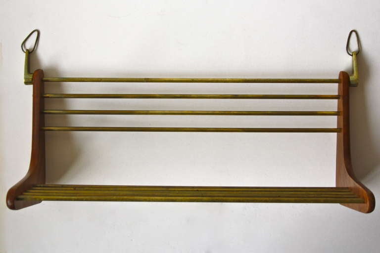Elegant wallmounted individual shelf in Walnut and brass by Carl Aubock. Perfect for the special books.