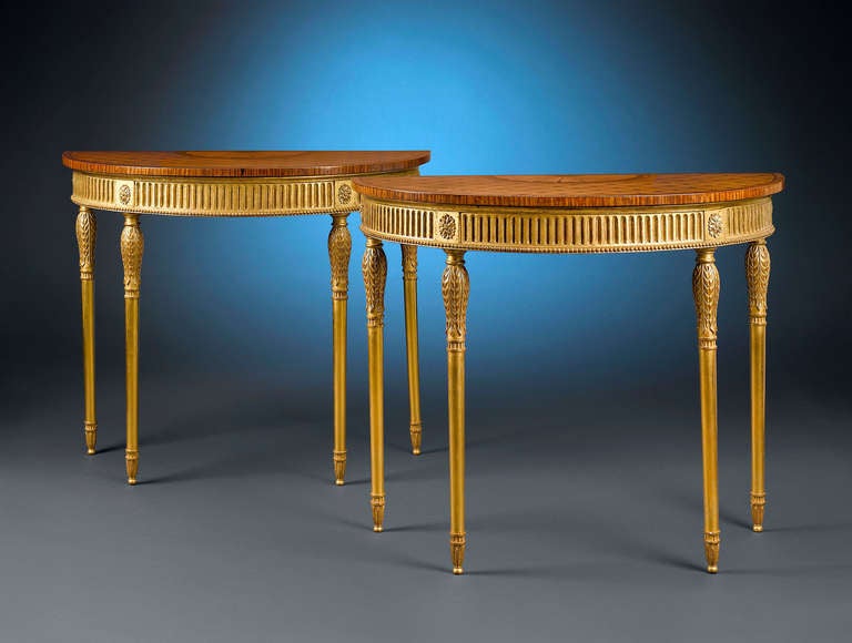 This extraordinary pair of demi-lune, or half-moon, side tables is exactly the kind of furniture to which Thomas Sheraton devoted his career. The surfaces of these tables are beautifully detailed with walnut and satinwood marquetry, inlaid with a