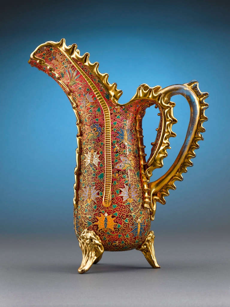 This rare and exceptional Moser cranberry pitcher exemplifies the outstanding artistry for which this firm is so renowned. Heavily decorated with enameled flowers, stems, leaves and butterflies throughout its entire surface, this ewer takes a