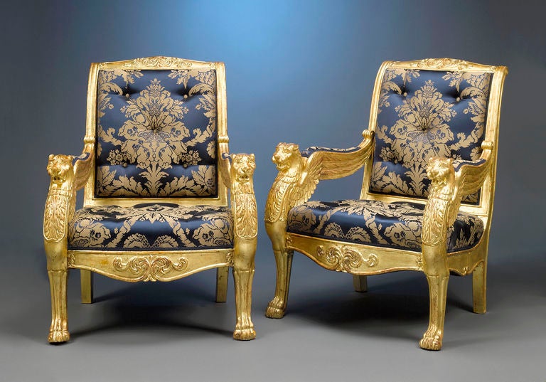 This magnificent pair of French giltwood armchairs is crafted in the manner of the Maison Jeanselme, the firm that created similar armchairs commissioned by Napoleon for General Jean-André Masséna, one of the greatest generals under the emperor’s