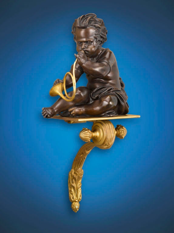 A duo of musically inclined putti play a horn and cymbals in this attractive pair of French wall brackets. The patinated bronze putti rest upon fine doré bronze platforms of elegant scroll form. Excellent condition.