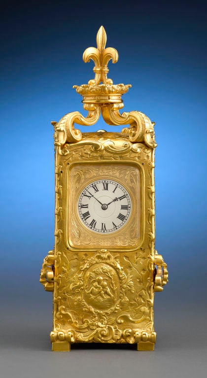 This rare and artistic timepiece gives new meaning to the term “carriage clock.” Displaying an exuberant Rococo motif, the clock is crafted of gilt bronze in the form of an 18th-century sedan chair, complete with detached carrying arms. The clock’s