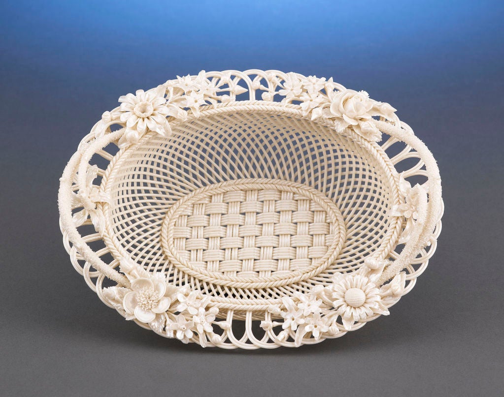 This exceptional Belleek porcelain basket is an outstanding example of the delicate artistry for which this Irish company is known. Carefully formed with a four-strand woven base, this basket features delicate twig handles and radiating latticework,